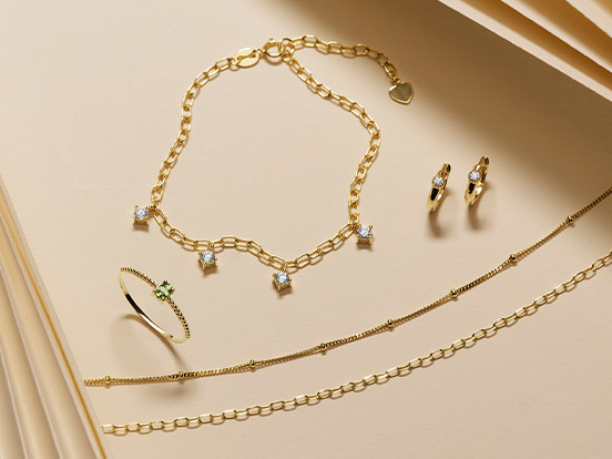 Link zu Damenschmuck. Ein Armband, zwei Ketten, ein Ring und zwei Ohrringe in Gold.