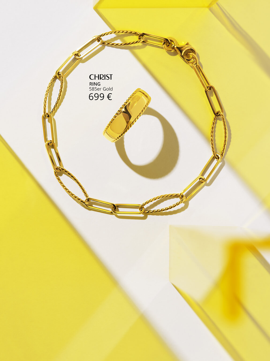 Goldenes Armband & Ring auf gelbem Plexiglas.