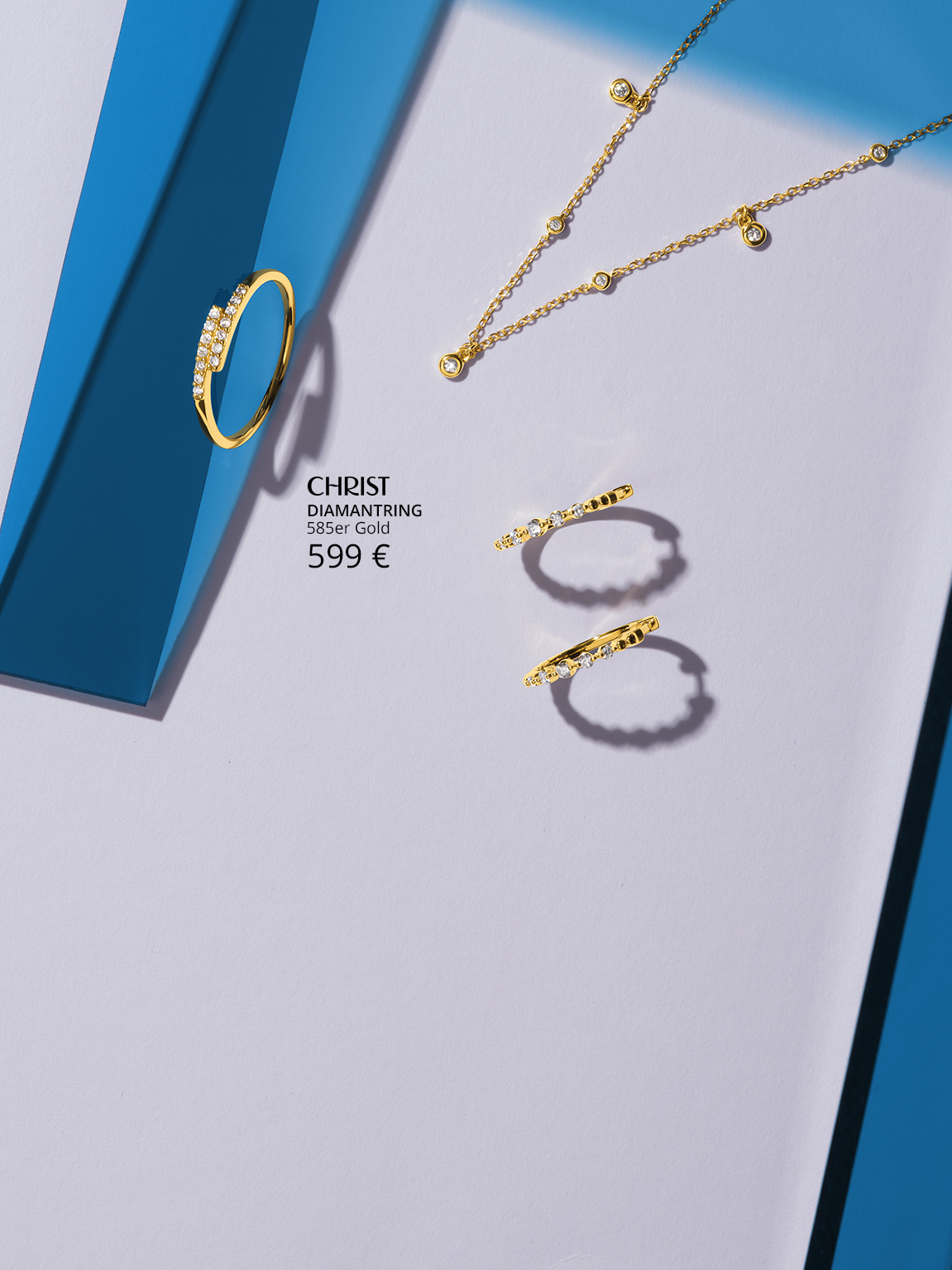 Diamantkette, Ring und Creolen mit blauen Formen.