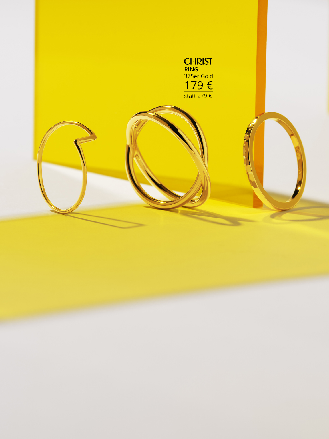 Drei goldene Ringe auf gelbem Hintergrund.
