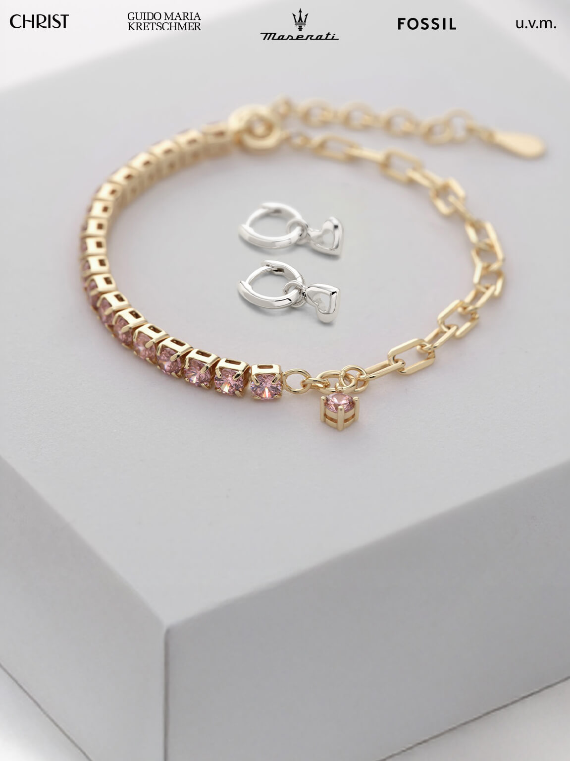 Armband und Creolen auf weißem Hintergrund.