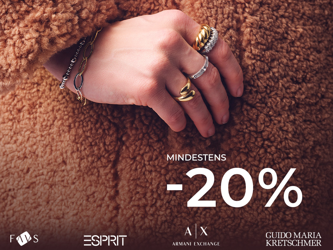 Hand mit goldenen und silbernen Ringen auf braunem Teddy-Stoff. Rechts Schrift: Mindestens -20 %. Marken unten.