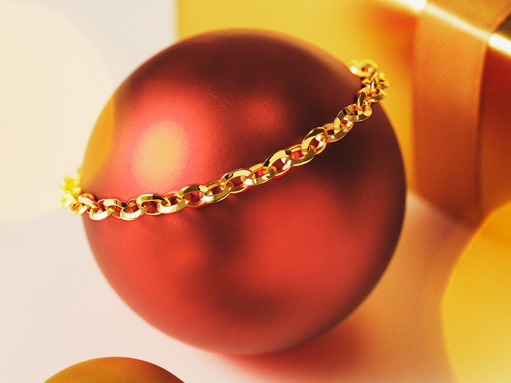 Goldenes Armband auf roter Kugel.