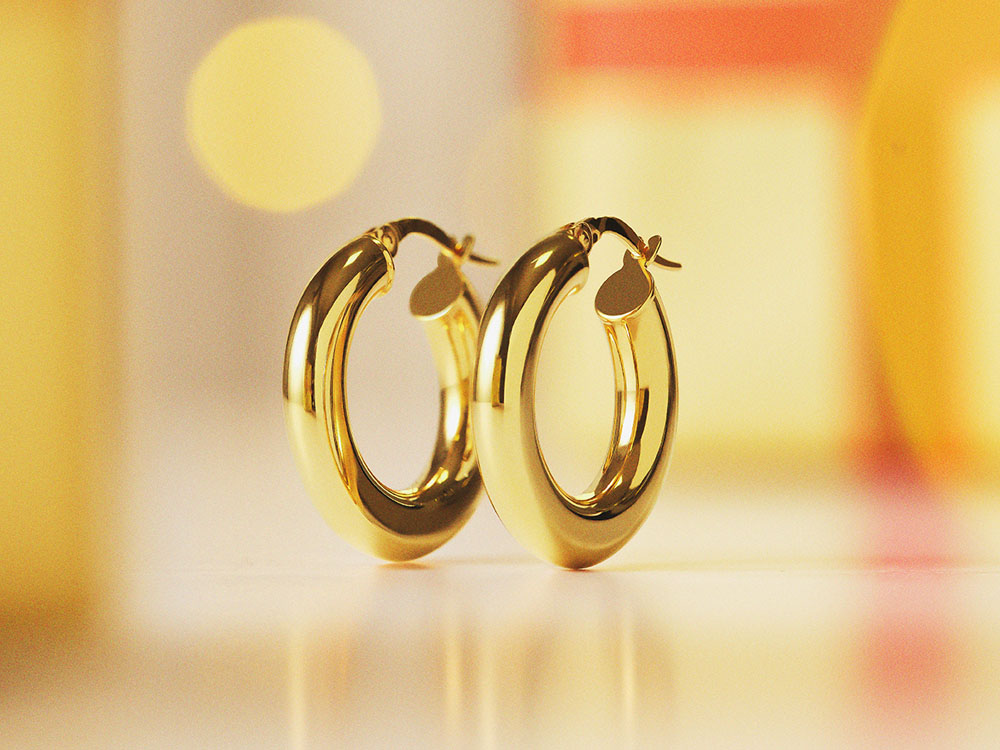 Goldene Creolen vor goldenem Hintergrund.