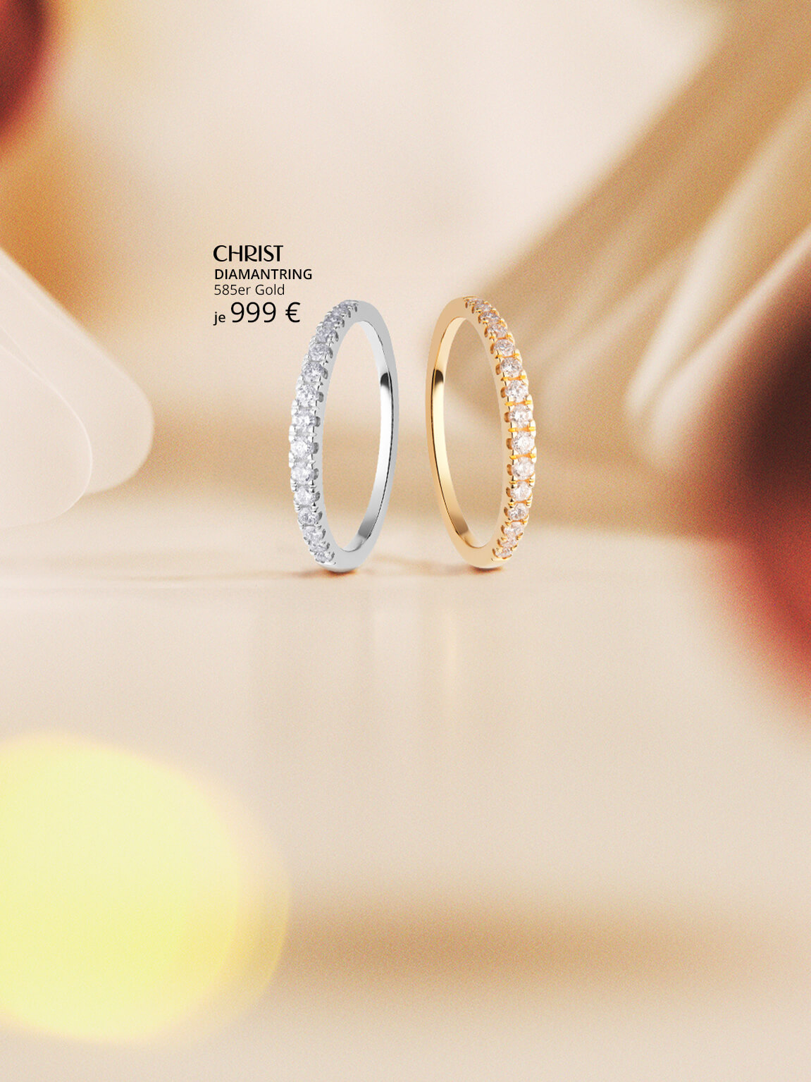 Memoire-Ringe in gelbgold und weißgold vor weihnachtlichem Hintergrund.