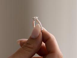 Brillantring in den Fingern einer Frau.