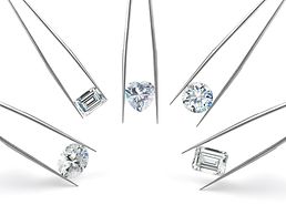 Diamanten in verschiedenen Schlifformen, gehalten von Pinzetten.