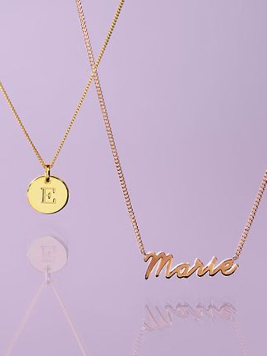 Zwei goldene Ketten von CHRIST X YOU mit Buchstabenanhängern personalisiert
