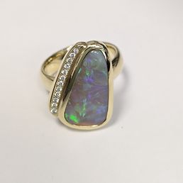 Ein Goldring mit einem großen Opal und seitlich angesetzten Diamanten