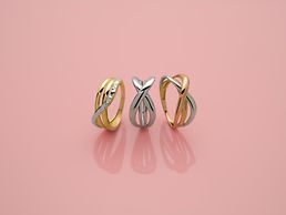 Drei Bicolor-Ringe in Gold und Silber mit verschlungenem Design.