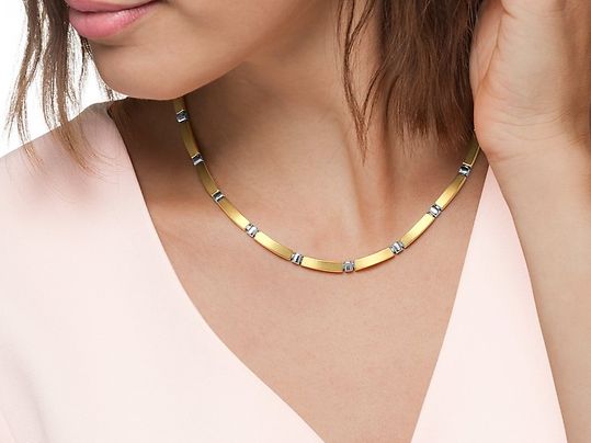 Frau trägt dezente Bicolor Kette zu einer schlichten Bluse.