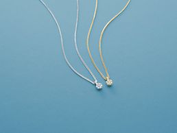 Eine gelbgoldene und eine weißgoldene Diamantkette nebeneinander.