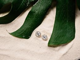 Diamantohrstecker im Sand - wir geben Tipps zur Schmuckpflege im Sommer und für den Strandurlaub.