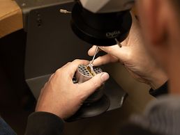 Goldschmied repariert einen Diamantring.