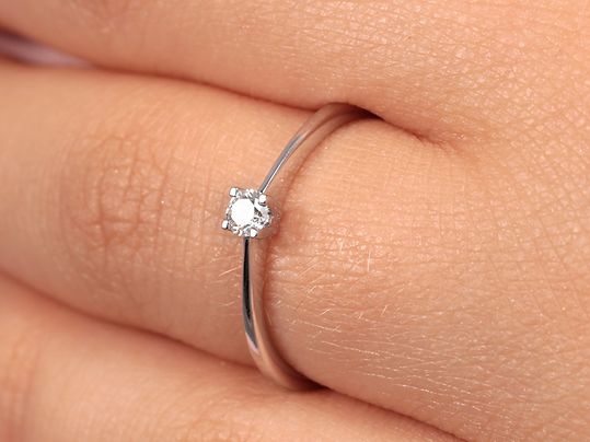 ein Diamant-Solitärring an einer Hand