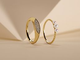 Link agli anelli. Un anello d'oro con pietre colorate e un anello d'oro con due perle.