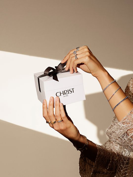 Vrouw houdt de CHRIST geschenkdoos omhoog.
