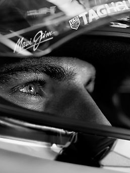 Das Gesicht von Max Verstappen mit Rennfahrerhelm in schwarz-weiß.