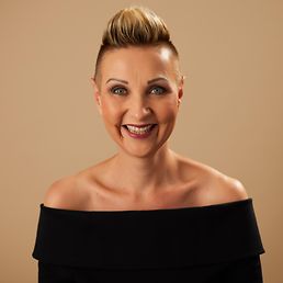 Portrait von Ines vor einem orangefarbenen Hintergrund.