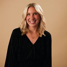 Portrait von Ines vor einem orangefarbenen Hintergrund.