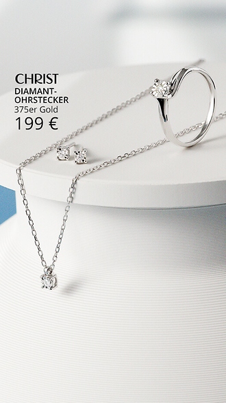 Diamantkette, Ring und Ohrstecker vor blauem Hintergrund.
