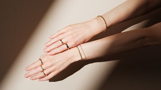 Zwei Arme mit gestackten Ringen und Armschmuck