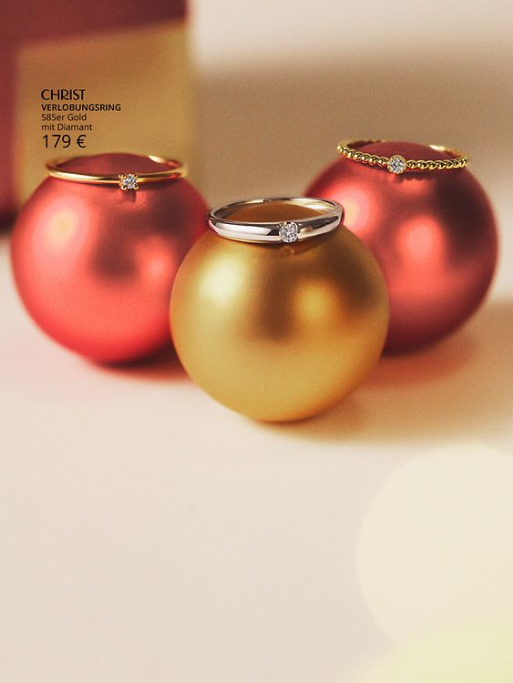 3 Verlobungsringe auf Weihnachtskugeln.