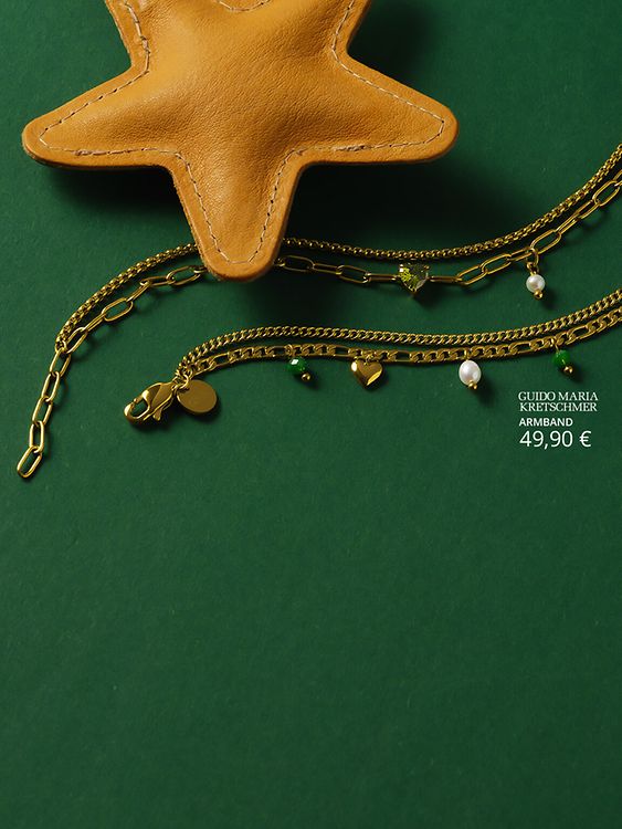 Goldene Armbänder auf grünem Hintergrund und Sternanhänger.