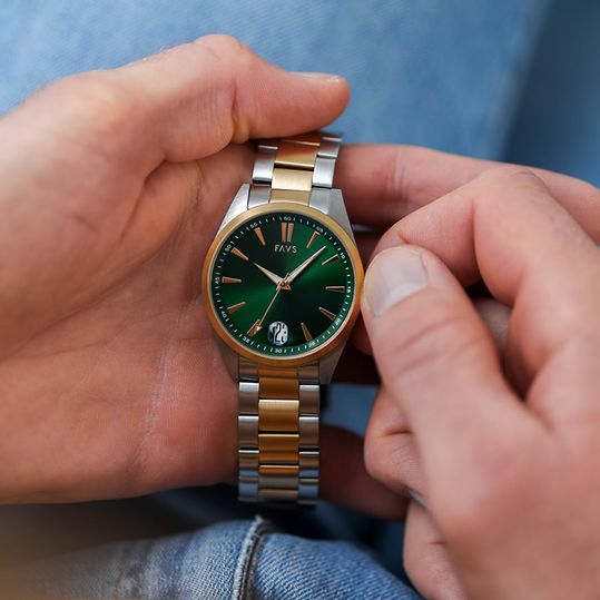 Bicolor Herrenuhr von FAVS mit grünem Ziffernblatt, die in der Hand gehalten und gestellt wird