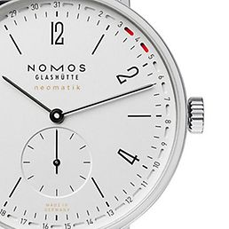 Eine silberne Uhr mit weißem Ziffernblatt von Nomos Glashütte.