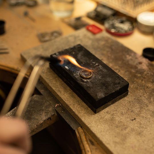 CHRIST Schmuckservice Ring Reparatur: Ein Ring wird mid einem Brenner in der Juwelierwerkstätte hartgelötet