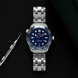 Die Omega Seamaster mit blauem Ziffernblatt auf schwarzem Hintergrund.